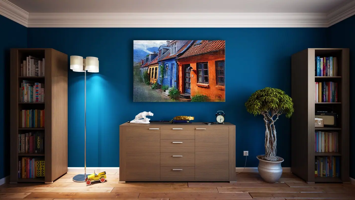 Low wooden dresser centered between two tall bookcases on a deep blue wall
