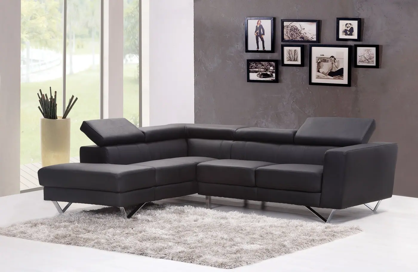 Large dark sectional sofa on a pale rug in a bright room